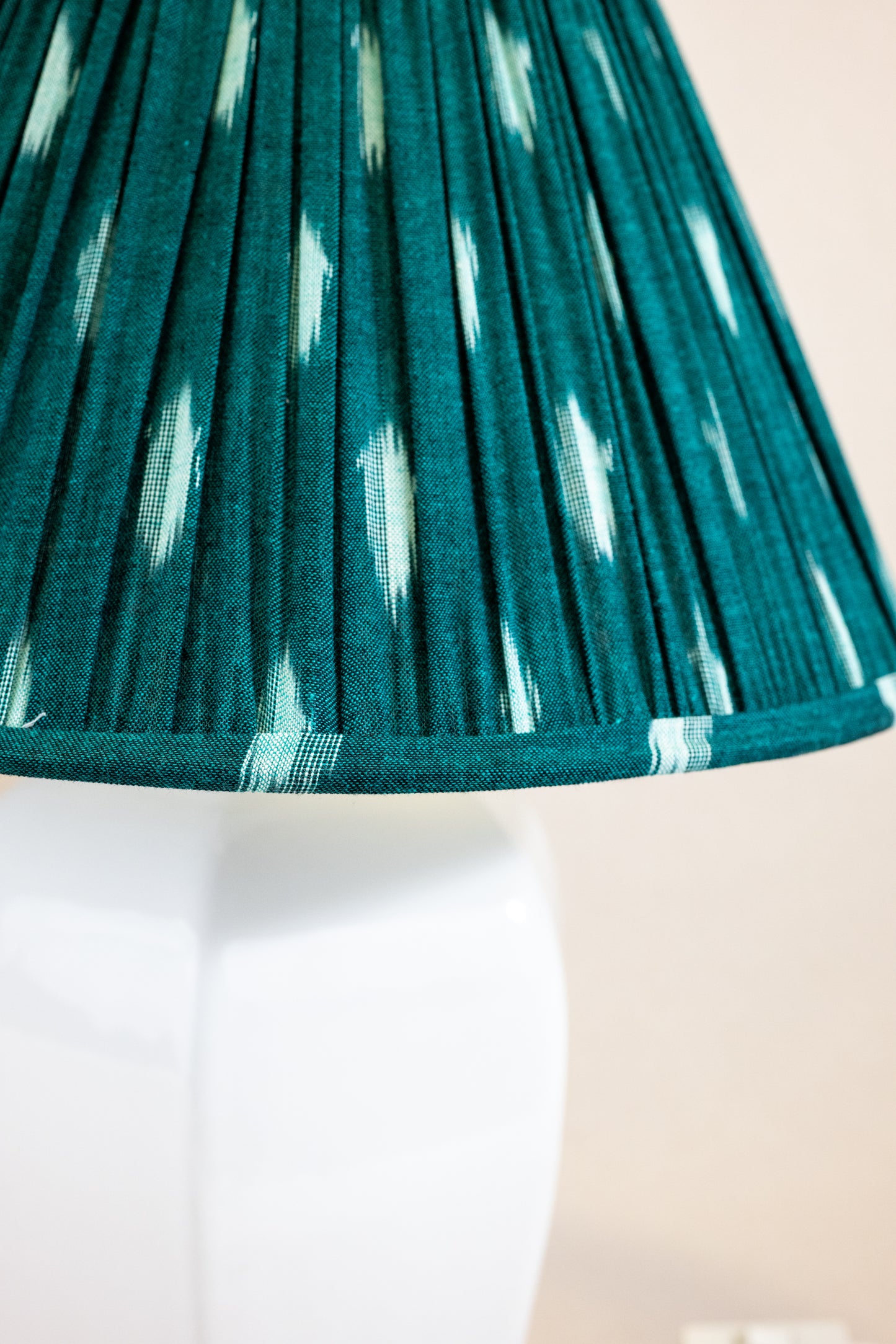 Table lamp with white hexagonal ceramic base and detail of green shade