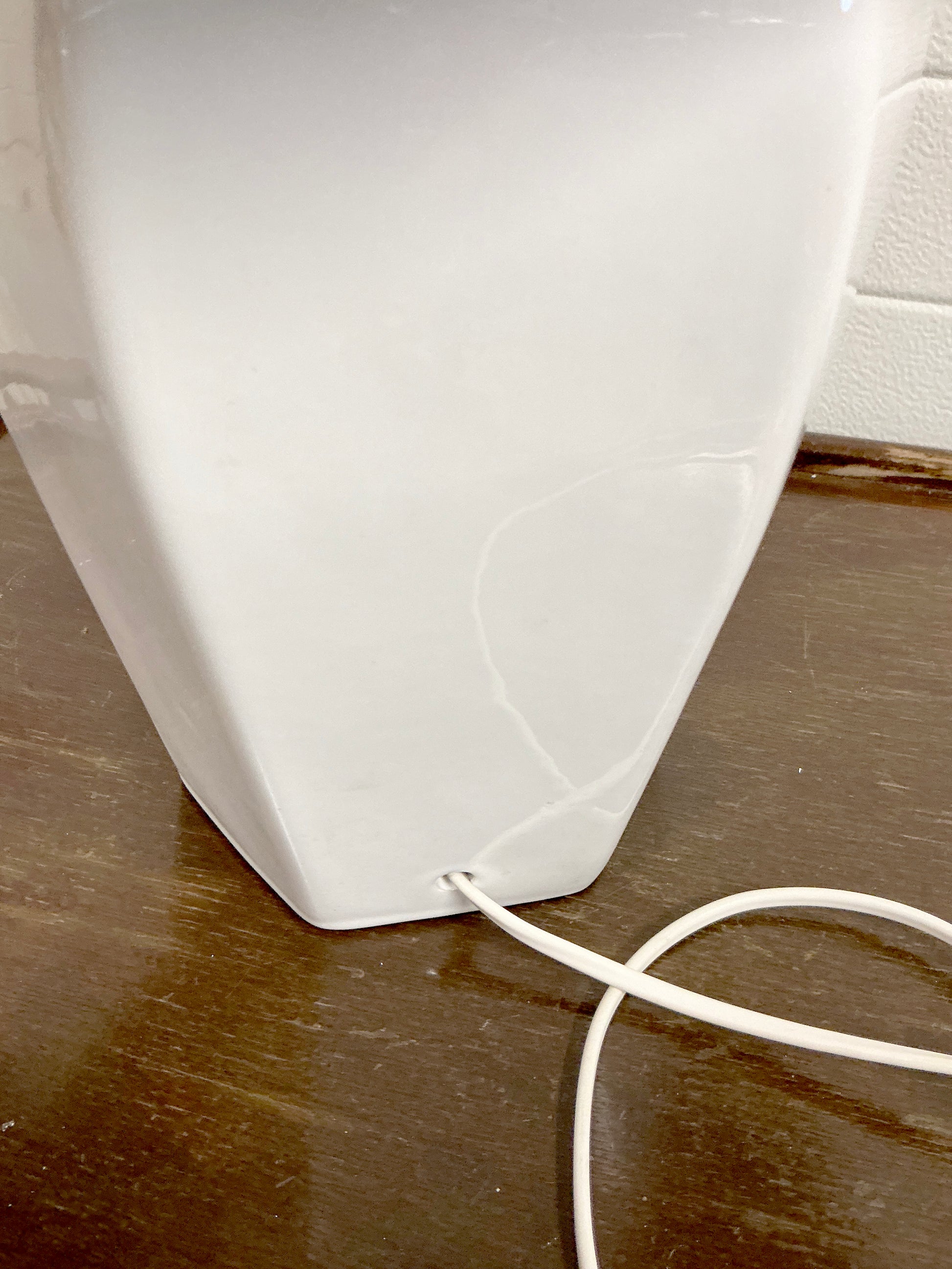 Table lamp with white hexagonal ceramic base and green shade bottom detail