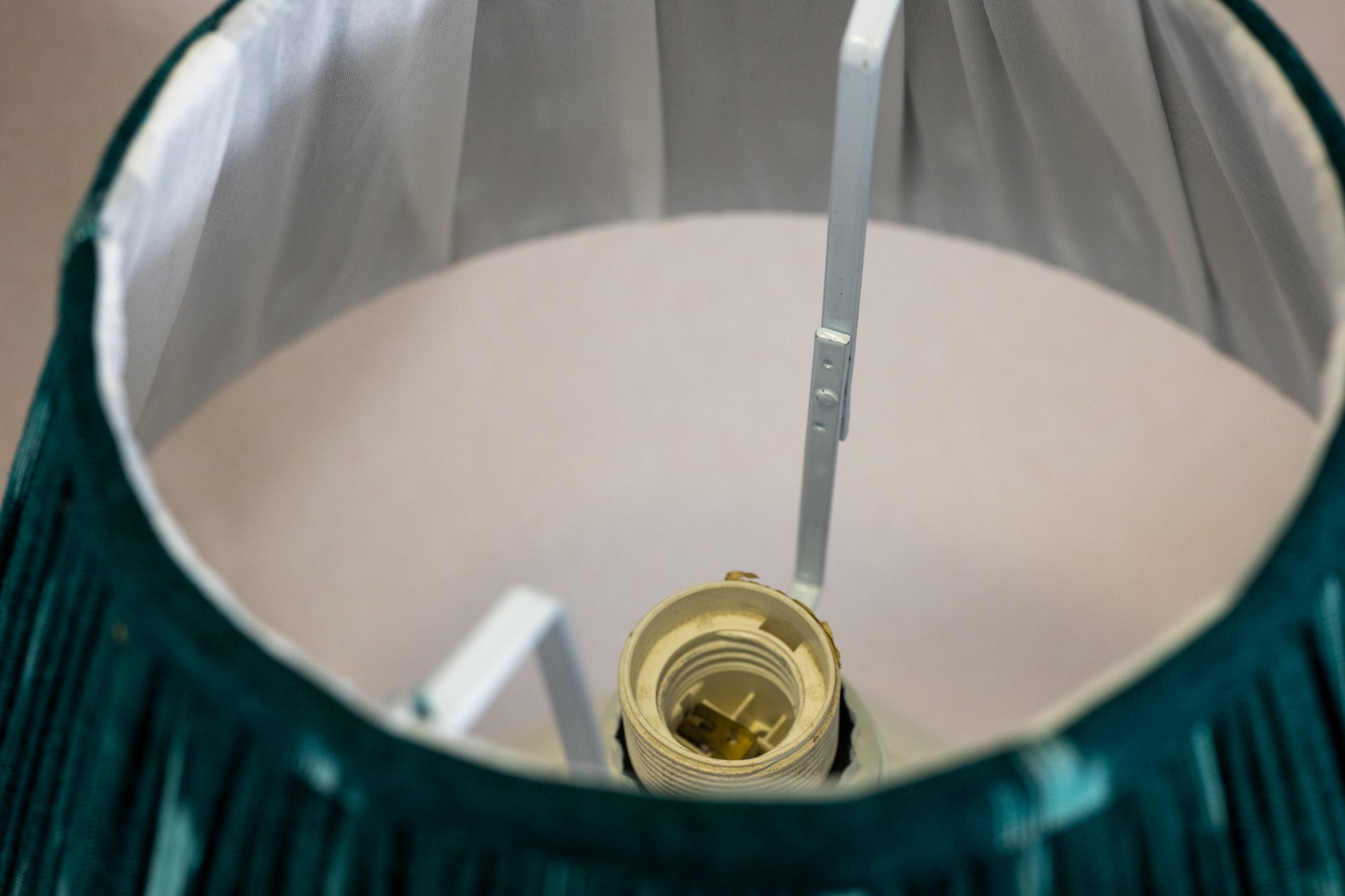 Table lamp with white hexagonal ceramic base and view through green shade