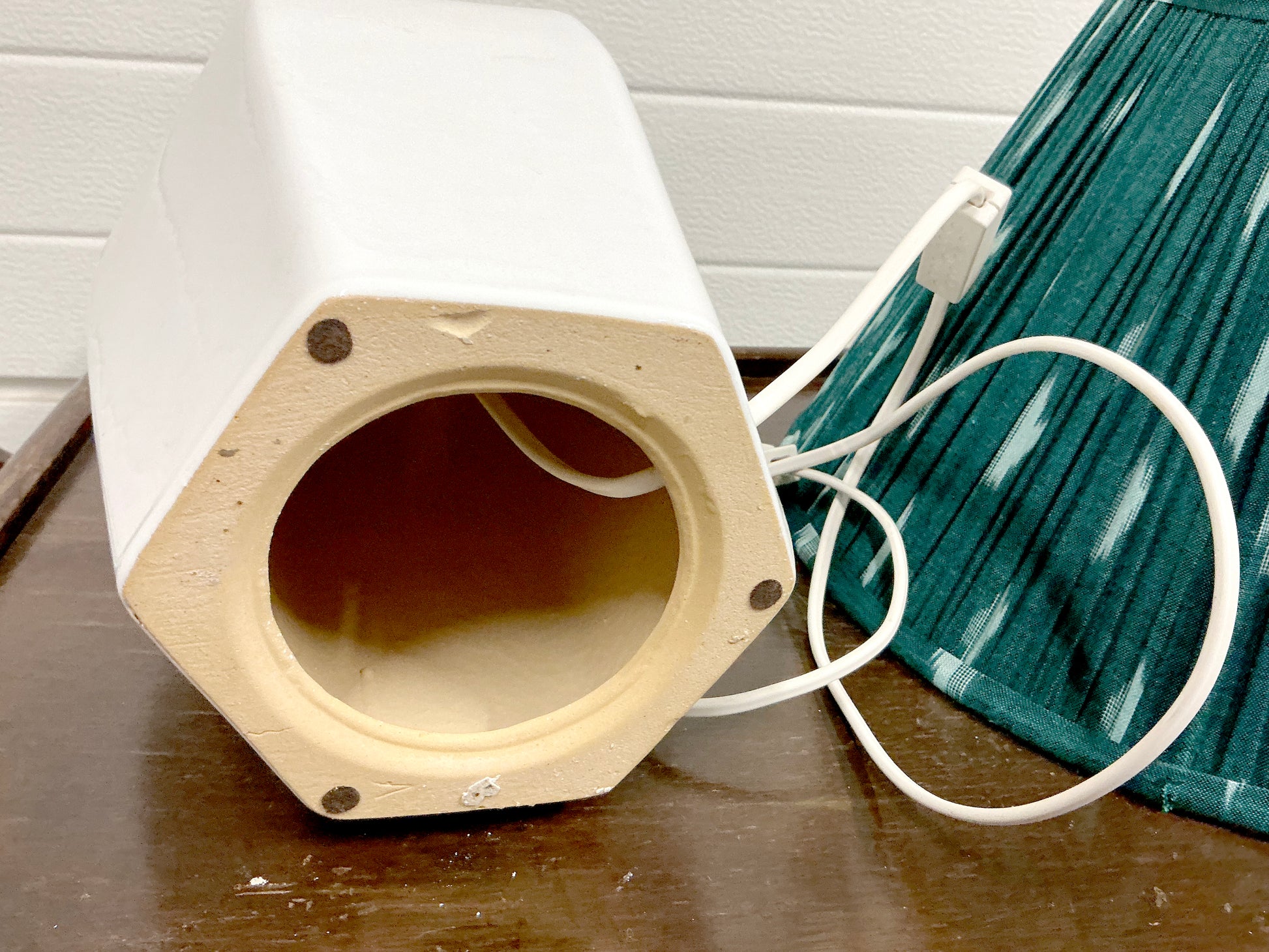 Table lamp with white hexagonal ceramic base with disassembled green shade